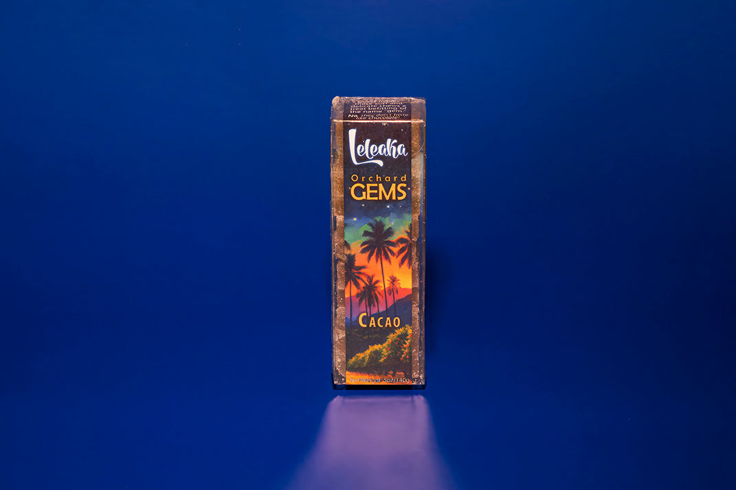 A clear box of Orchard Gems pate de fruit cacao candy in front of a blue background